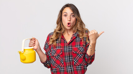 pretty thin woman looking astonished in disbelief and holding a teapot