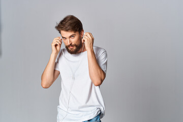 Cheerful bearded man on a white t-shirt emotions holds his hand near his face