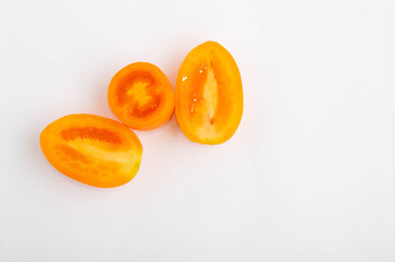 three yellow sliced tomatoes on a white background. Food, vegetables