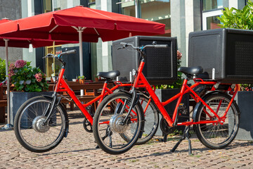 Fototapeta na wymiar two red bikes with black delivery boxes