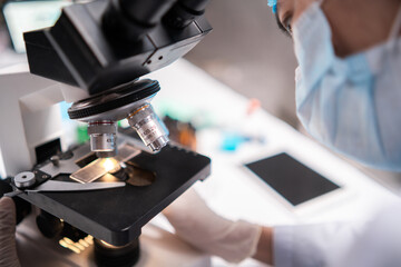 scientist looking through scientific microscope lense in laboratory, scientist doing research in term of medicine biotechnology biology or chemistry, doctor analyzing work in medical microbiology lab