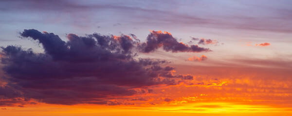 Dramatic colorful red orange to dark blue sunset or sunrise sky landscape clouds. Natural beautiful cloudscape dawn background wallpaper. wide banner nature twilight dusk scene panorama