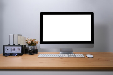 Blank screen desktop of computer on wooden table, comfortable workspace.