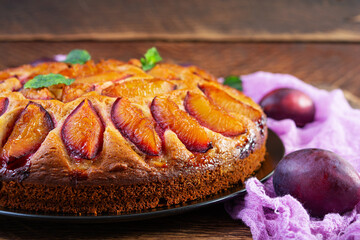 Delicious plum cake on wooden background. Homemade plum pie