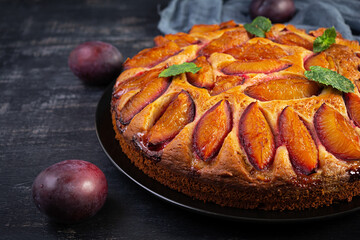 Delicious plum cake on wooden background. Homemade plum pie