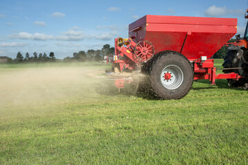Fertilizer spreader. Fertilizer. Tractor. Farming. Meadow. Grass. Chalk. Netherlands