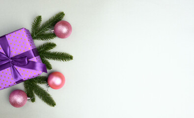 purple gift box tied with ribbon on a gray background, top view. Festive backdrop, copy space
