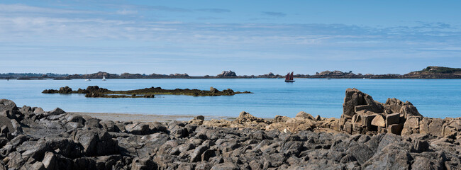rocks and beach near ile de Bréhat in the north of brittany in france under blue sky