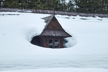 Cottage window covered by snow. House in the High Tatras at Morskie Oko