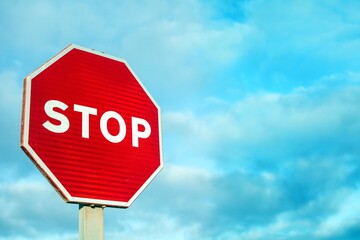 Stop sign with cloudy sky background