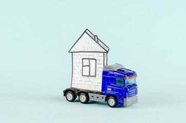 Toy tractor-trailer carrying a house. Blue plastic truck and hou