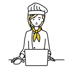 デスクで座ってPCを使っている調理師の女性