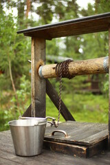 Rural wooden fountain with a metal bucket