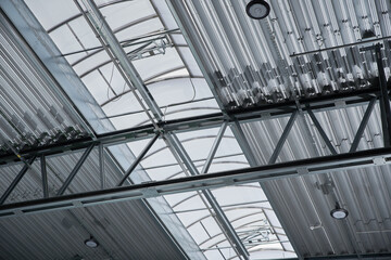 Metal roof of the production area reinforced with fittings with lamps and ventilation windows