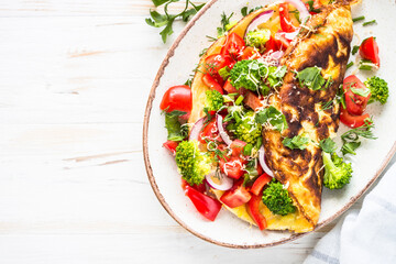 Omelet with fresh vegetables - broccoli, tomatoes and paprika. Healthy breakfast. Top view image.