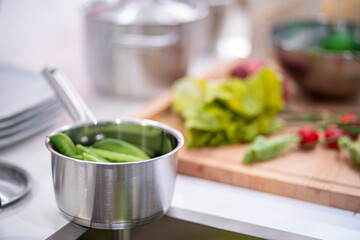 image of aluminium pot with vegetables on the kitchen table