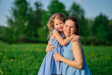 nature scene with family outdoor lifestyle. Mother and little daughter playing together in a park. Happy family concept. Happiness and harmony in family life.