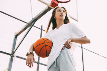 Portrait of young female basketball player. Beautiful teen girl playing basketball. in sportswear...