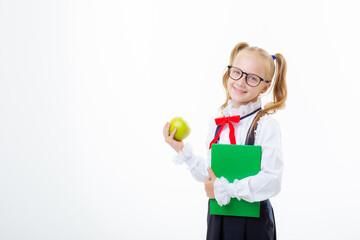  little girl in a school uniform holds a book and an apple isolated on a white background