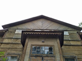 old and abandoned wooden building against the gray sky. bottom up view photo.