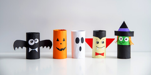 The concept of a fun Halloween. Crafts from toilet rolls and colored paper pumpkin, bat, ghost, witch.