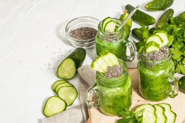 Green smoothie with cucumber in a glass jar. Fresh ripe vegetables, greens, and chia seeds