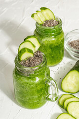 Obraz na płótnie Canvas Green smoothie with cucumber in a glass jar. Fresh ripe vegetables, greens, and chia seeds
