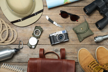 Flat lay composition with different safari accessories on wooden background © New Africa
