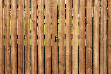 Old and weathered wooden planked gates with padlock