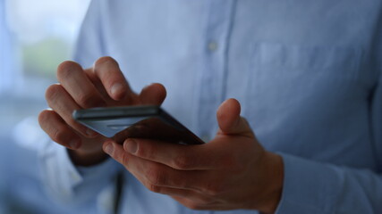 Businessman hands scrolling web pages on touch screen of smartphone