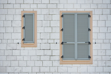 Fototapeta na wymiar Modern gray plastic window shutters on brick wall