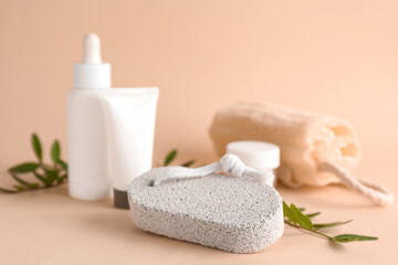 Obraz na płótnie Canvas Pumice stone, cosmetic products and loofah on beige background