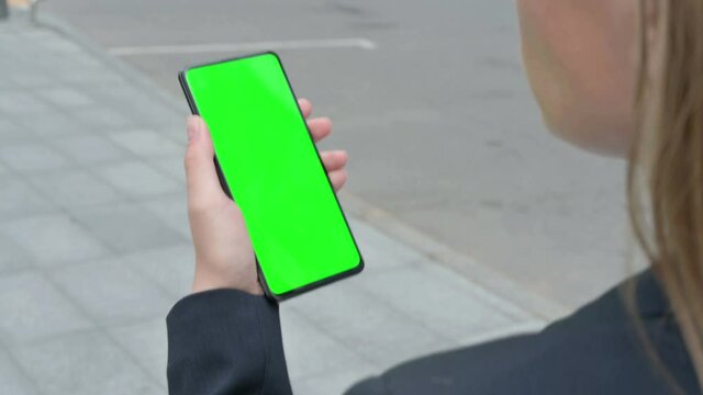 Rear View of Businesswoman Looking at Smartphone with Green Chroma Screen 
