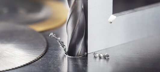 Drill bit with steel triangle ruler make holes in steel billet on industrial drilling...