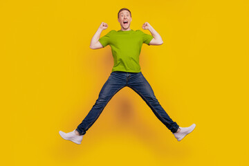 Fototapeta na wymiar Full size photo of nice attractive cheerful optimistic guy having fun jump up ecstatic winner isolated over yellow background