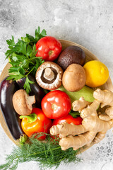  A mix of vegetables,, herbs, and mushrooms on a light gray background	