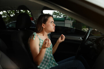Stressed young woman in driver's seat of modern car