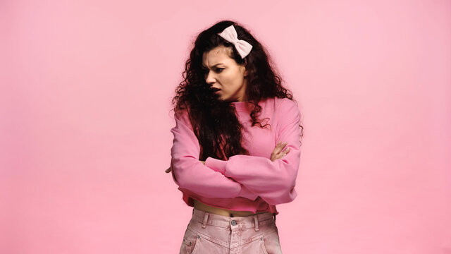 Offended Woman Turning Away While Standing With Crossed Arms Isolated On Pink