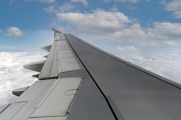 Fototapeta na wymiar Airplane with blue sky and white puffy clouds.