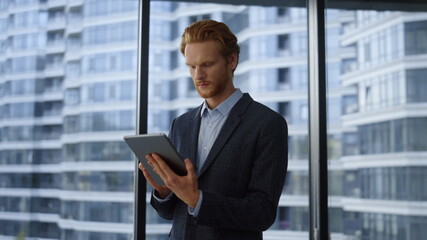 Fototapeta premium Businessman using digital tablet in office.Professional reading good news on pad