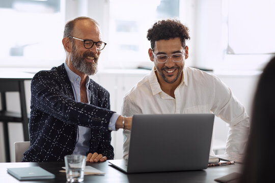 Men using laptop at business meeting
