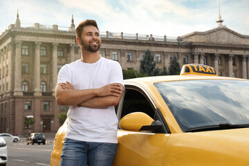 Handsome taxi driver near car on city street