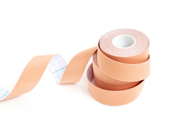 Pile of lifting or kinesio tape rolls on white surface