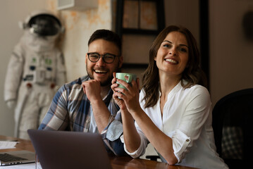 Colleagues in office. Two friends drinking coffee while working in the office.