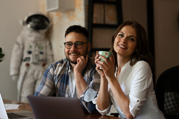 Colleagues in office. Two friends drinking coffee while working in the office.