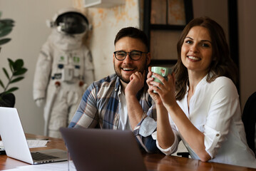Colleagues in office. Two friends drinking coffee while working in the office.