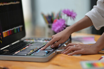 Closed up of hands selecting a color of crayon.