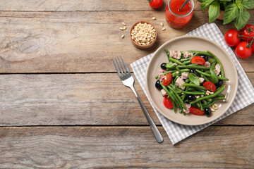 Tasty salad with green beans served on wooden table. Space for text