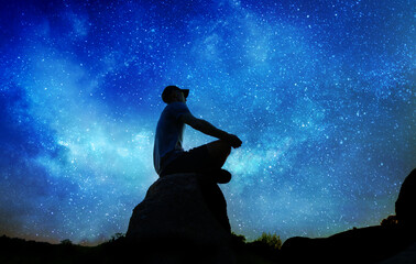silhouette of man sitting and practicing outdoors, person does yoga meditation © andreusK