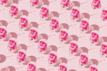 Creative pattern made of glass with hibiscus flower water on pastel pink background with sunlit. Summer and refreshment concept. Minimal style